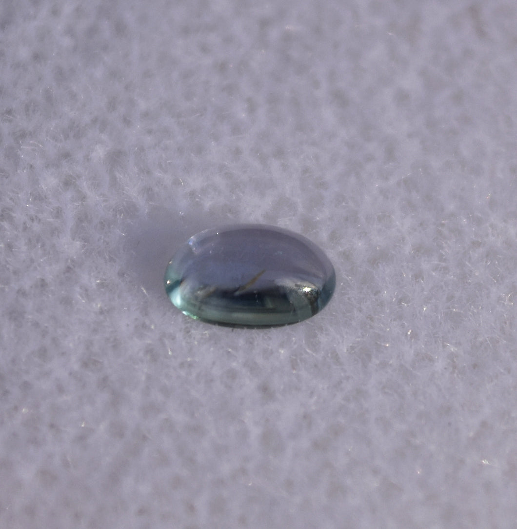 Purple-Facing Chrome Kornerupine Cabochon with Teal Axis - 0.3 ct.